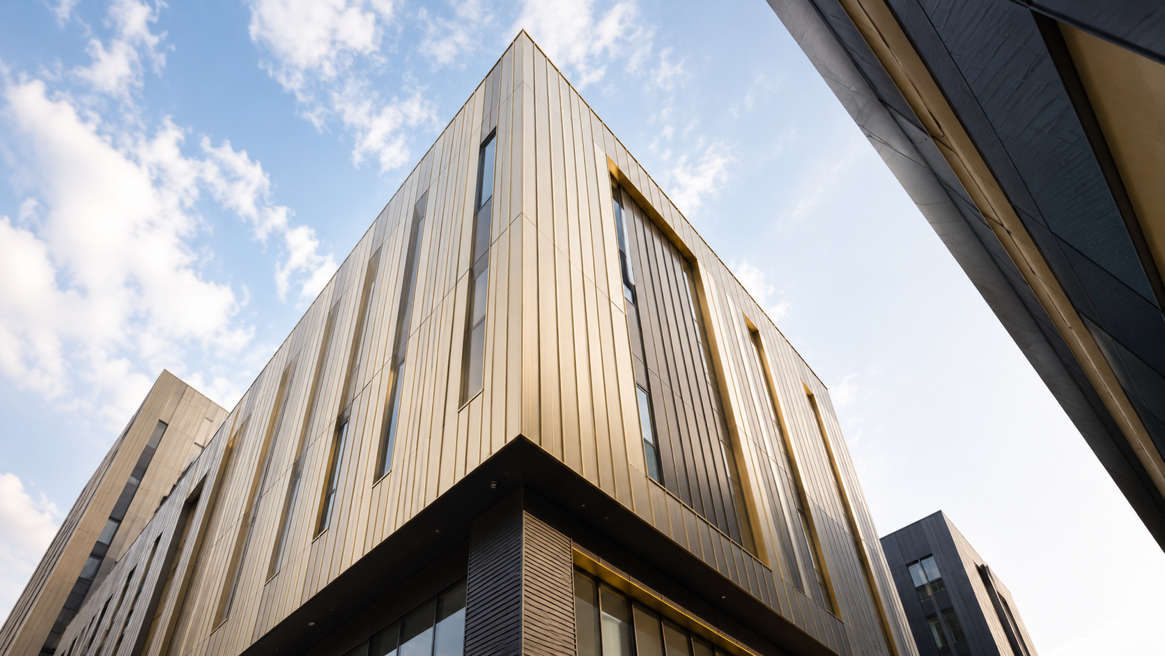 Modern bronze-clad rainscreen facade by TSC Facades on a UK commercial building against a clear sky